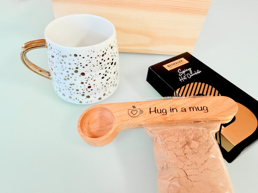 Mug, wooden spoon/clip with 'Hug in a mug' text, and hot chocolate mix